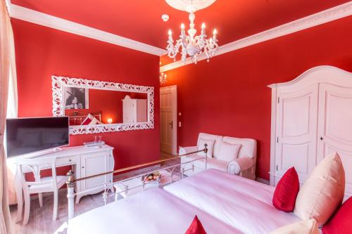 a bedroom with red walls and a bed and a mirror at Grande Albergo Giancarlo in Weimar