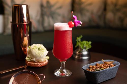 a drink in a glass on a table with a bowl of food at Koulen Central Hotel in Siem Reap