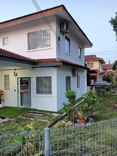 ein weißes Haus mit einem Zaun davor in der Unterkunft Homestay HNH Melaka (Corner Lot) in Malakka