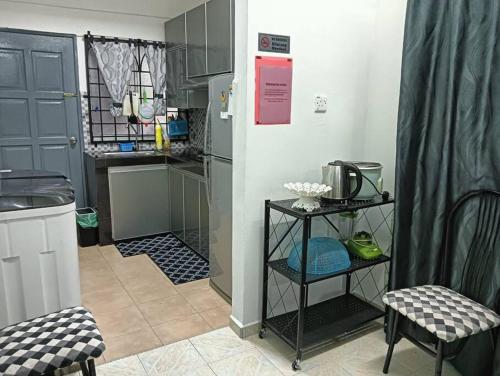 a kitchen with a refrigerator and a table and chairs at Homestay HNH Melaka (Corner Lot) in Melaka