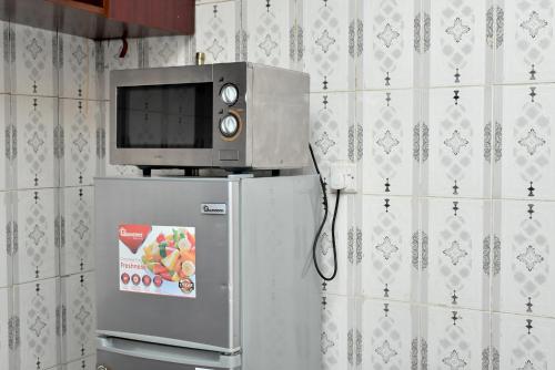 a microwave on top of a refrigerator in a kitchen at Ramsi apartment in Nairobi