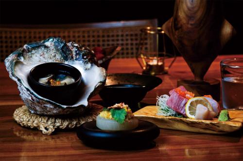 a table with sushi and a bowl on a table at Miru Amami in Tatsugo