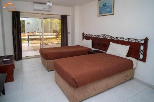 ein Hotelzimmer mit zwei Betten und einem Fenster in der Unterkunft Fox Beach Stay in Hurghada