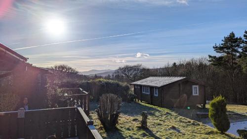 a small house in a yard with a fence at Snowdonia Log cabin in Trawsfynydd
