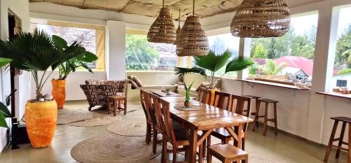 a dining room with a table and chairs and windows at Mlango Paje House II in Paje