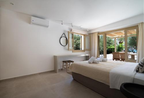 a bedroom with a bed and a large window at Glaros Kouremenos in Palekastron