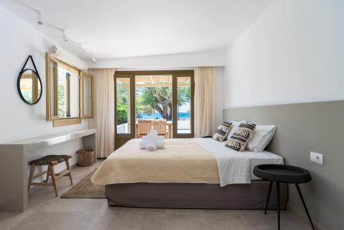 a bedroom with a king sized bed and a balcony at Glaros Kouremenos in Palekastron