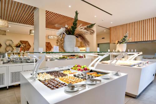a buffet line with fruits and vegetables on display at White Olive Elite Laganas in Laganas