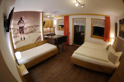 a hotel room with two beds and a desk at Appartement Wälderhof in Kaprun