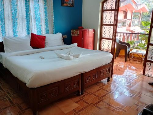 a bedroom with a bed with two white towels on it at FLOBESTIAN BEACH VILLA CANDOLIM BEACH in Aguada
