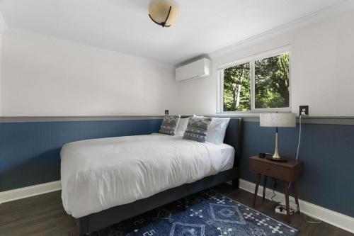 Dormitorio azul y blanco con cama y ventana en Blueground Beacon Hill nr groceries parks SEA-702 en Seattle