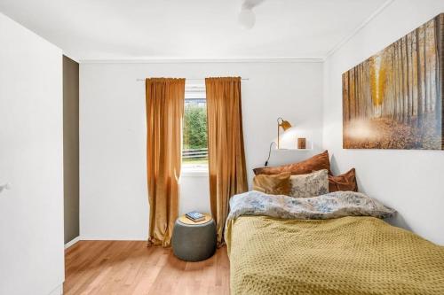 een slaapkamer met een bed en een raam bij Moderne sentralt hjem in Tromsø