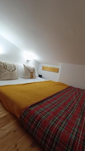 a bedroom with a large bed with a plaid blanket at Campo Felice Apartment in Collimento