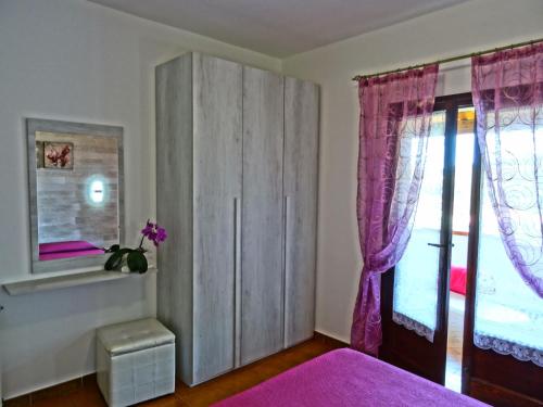 a bedroom with a cabinet and a window at LA RESIDENZA NEL PARCO BIKE HOUSE in Capoliveri