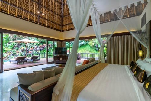 a bedroom with a bed and a living room at The Hidden Palace by Hanging Gardens in Payangan