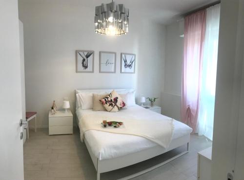 een slaapkamer met een wit bed en een kroonluchter bij Suite Locchi. Vicino Tramvia/Careggi/Meyer in Florence