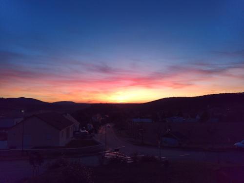 a sunset with the sun setting in the sky at Gîtes de l'Orée du Bois - Boussières in Boussières