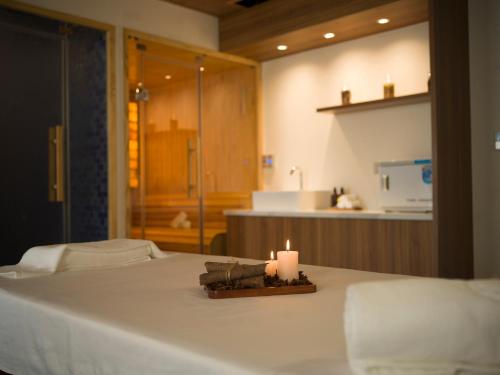 a candle sitting on top of a bed in a room at MerPerle Dalat Hotel in Da Lat
