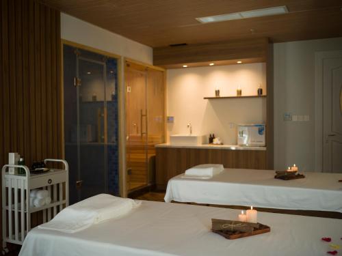 duas camas num quarto com duas velas em MerPerle Dalat Hotel em Da Lat