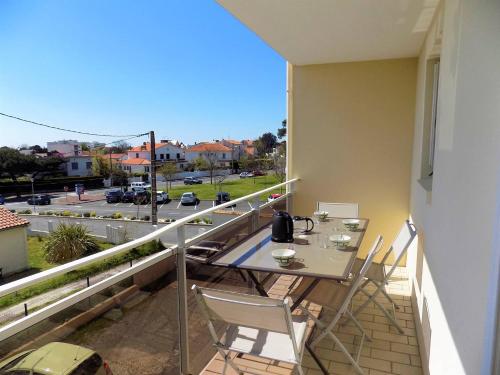 a balcony with a table and chairs and a view of a street at Royan - APPARTEMENT VUE MER - à SEULEMENT 300m PLAGE et COMMERCES in Royan