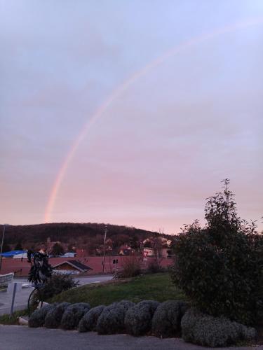 a rainbow is in the sky over a city at Gîtes de l'Orée du Bois - Boussières in Boussières