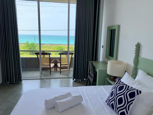 a bedroom with a bed and a view of the ocean at Villa beachcomber in Ambalangoda