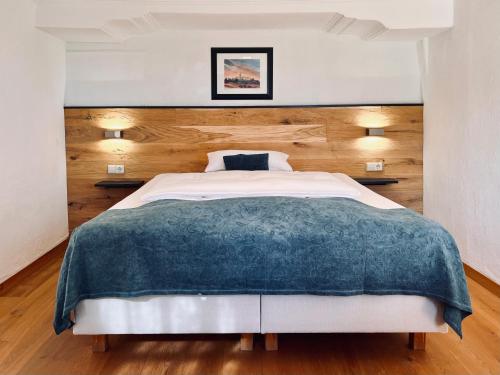 a bedroom with a large bed with a wooden headboard at Gasthof Wäscherschloss in Wäschenbeuren