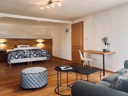 een slaapkamer met een bed, een bank en een tafel bij Gasthof Wäscherschloss in Wäschenbeuren