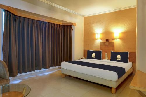 una camera d'albergo con letto e tavolo di Super Townhouse Oak Orchard Hotel a Pune