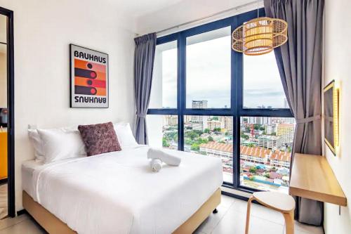 a bedroom with a white bed and a large window at Urban Suites George Town in Jelutong