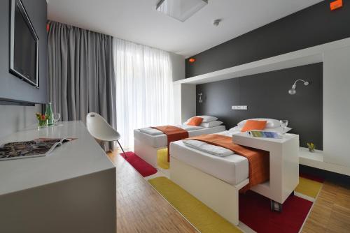 una camera d'albergo con 2 letti e una scrivania di Omnia Hotel Relax & Wellness a Janské Lázně