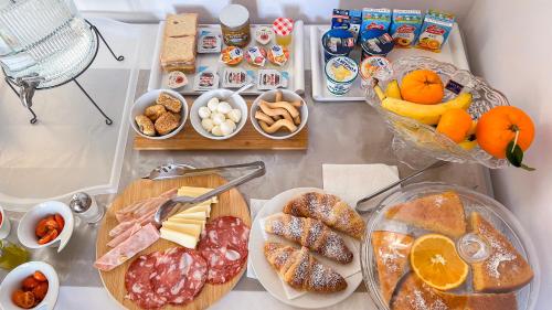 uma mesa com diferentes tipos de alimentos para o pequeno-almoço em Promenade B&B em Catânia