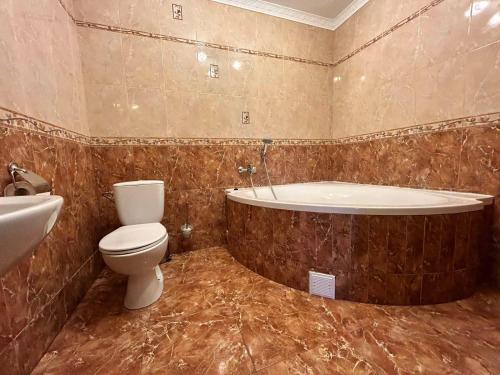 een badkamer met een bad, een toilet en een wastafel bij Europe in Solonka