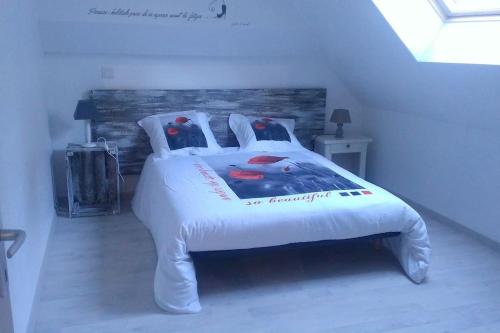 a bedroom with a white bed with two birds on it at Gite à la ferme du chateau in Saint-Dolay