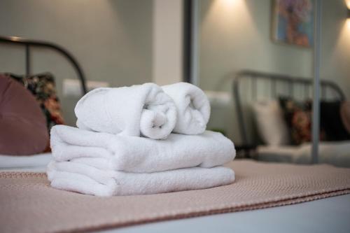 uma pilha de toalhas sentadas em cima de uma cama em Zappa 2-Bedroom Apartment in Athens em Atenas