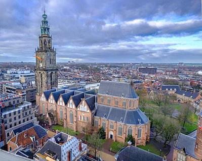 a large building with a clock tower in a city at EnJoy Meer und See Ferienhaus -In Lauwersoog- 1-6 Pers- 3 Schlafzimmer in Lauwersoog