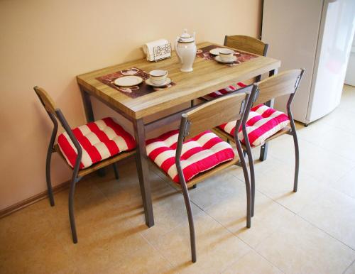 a wooden table with two chairs and a table with aeder at Willa Alwa in Iława