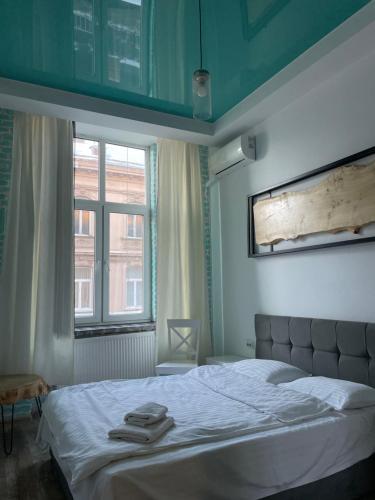 1 dormitorio con 1 cama con 2 toallas en Apartments Zefir on Vynnychenka, en Leópolis