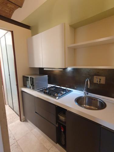 uma cozinha com um lavatório e um fogão em Baccio - studio apartment em Montelupo Fiorentino