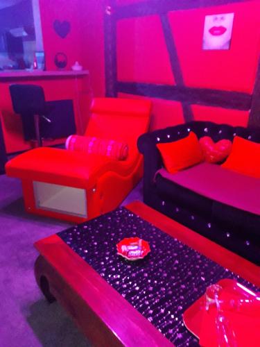 a living room with red and black furniture at LOVE ROOM Le rouge et noir in Barr