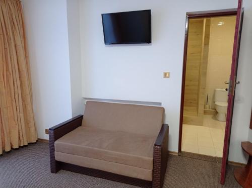 a room with a chair and a television on a wall at Hotel LUDMIR in Volodymyr-Volynsʼkyy