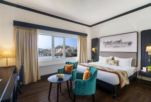 um quarto de hotel com uma cama, uma mesa e cadeiras em Rajdarshan - A Lake View Hotel in Udaipur em Udaipur