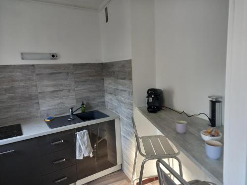 uma cozinha com um lavatório e um balcão com uma cadeira em Le studio zen em Gray
