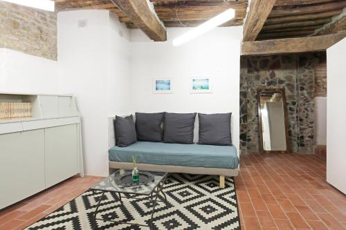 sala de estar con sofá azul y alfombra en A casa di Paola, en Castagneto Carducci