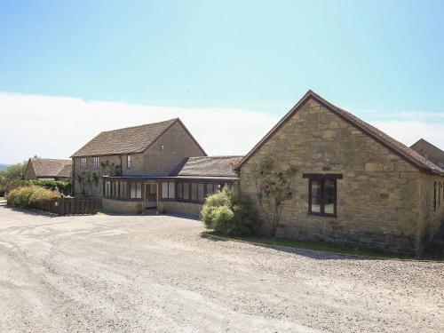 a large stone house with a gravel driveway at Finest Retreats - The Walton in Onibury