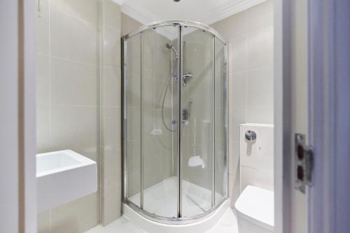 um chuveiro com uma porta de vidro na casa de banho em The London Cradle - Spacious 1BDR Flat em Londres