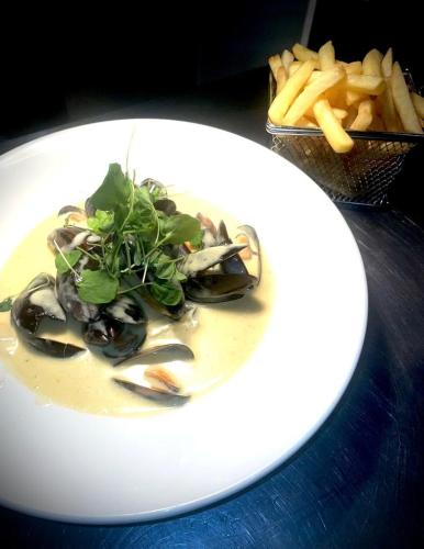 a white plate of food with a bowl of fries at The Aberlour Hotel in Aberlour