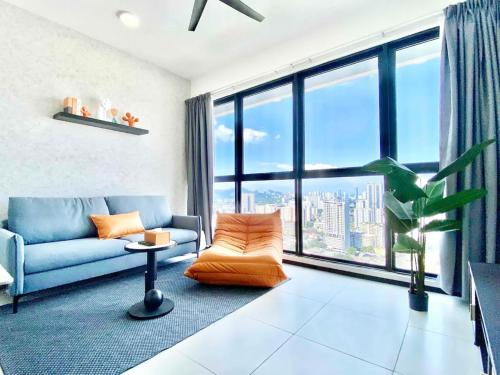 a living room with a couch and a large window at Urban Suites George Town in Jelutong