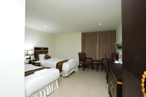 LUCKY PALACE HOTEL في بانكوك: غرفة فندقية بسريرين وطاولة