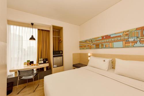 a hotel room with a bed and a desk at Maxone Premier Melawai in Jakarta